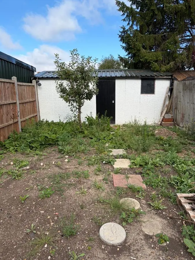 Lawn with stepping stones and full borders: the garden before