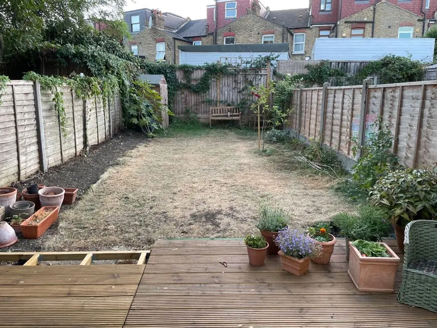 Long lawn framed by borders, from the deck: the garden before