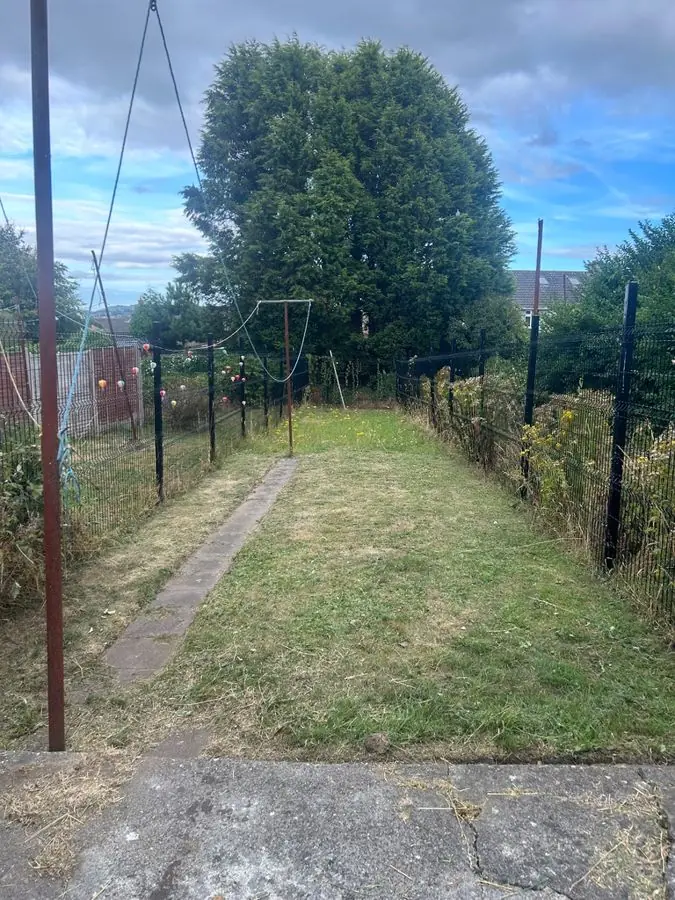 A long narrow lawn with a washing line and wire fences, before the redesign