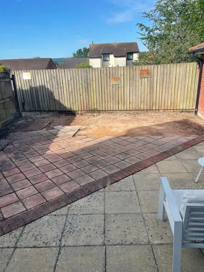 A bare red block paved area beside a grey slab patio, before the redesign