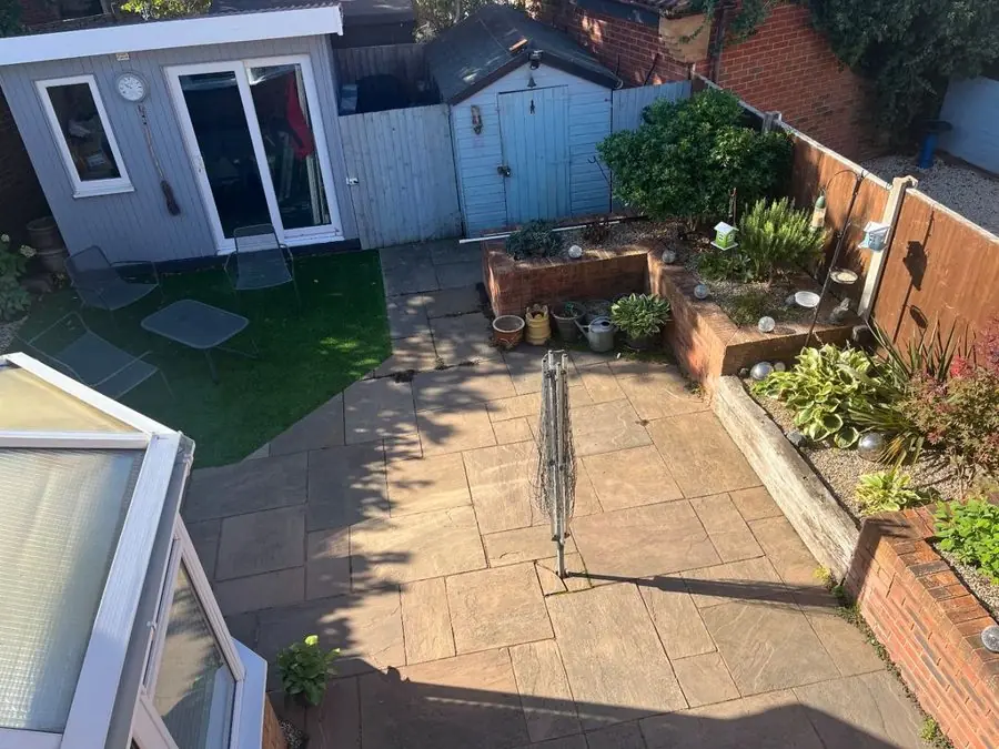 Patio with steel planters and a seating corner: the garden before