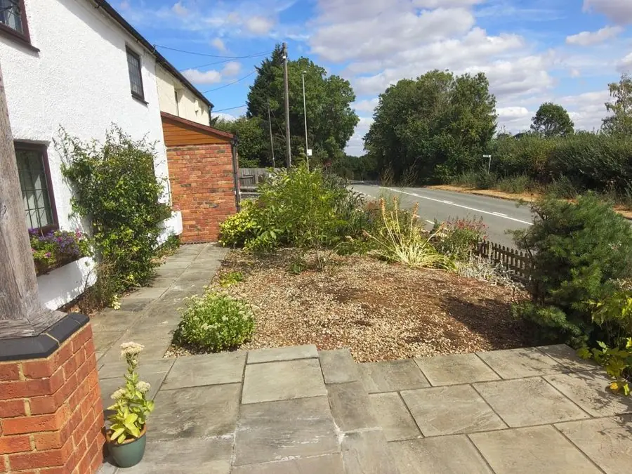 Gravel, lavender and dark leaves by a cottage: the garden before