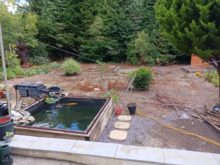 Round lawn and a stone water feature: the garden before