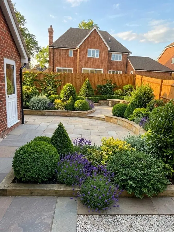 Curved patio with clipped evergreens, redesigned with the app