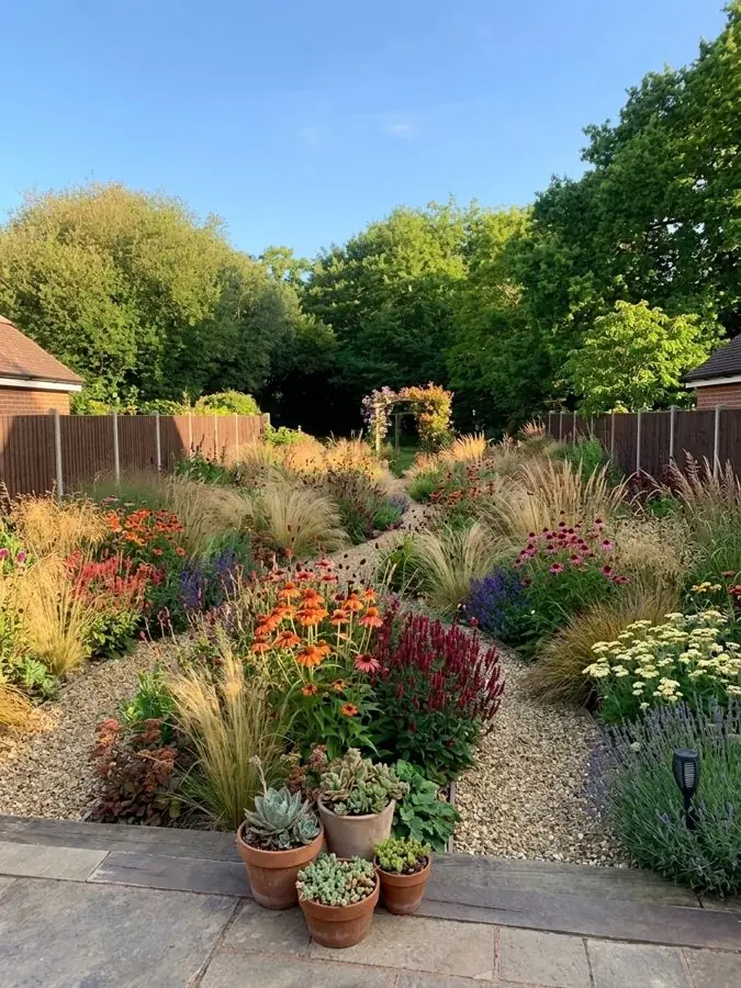 Grasses and gravel with orange daisies, a lawn garden idea