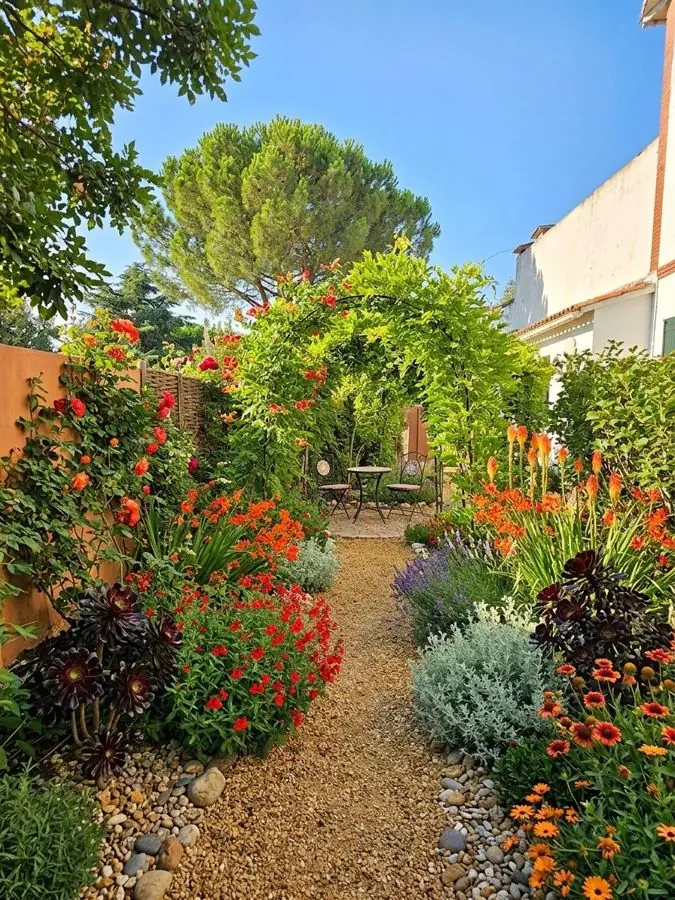 Gravel path through red and orange planting, redesigned