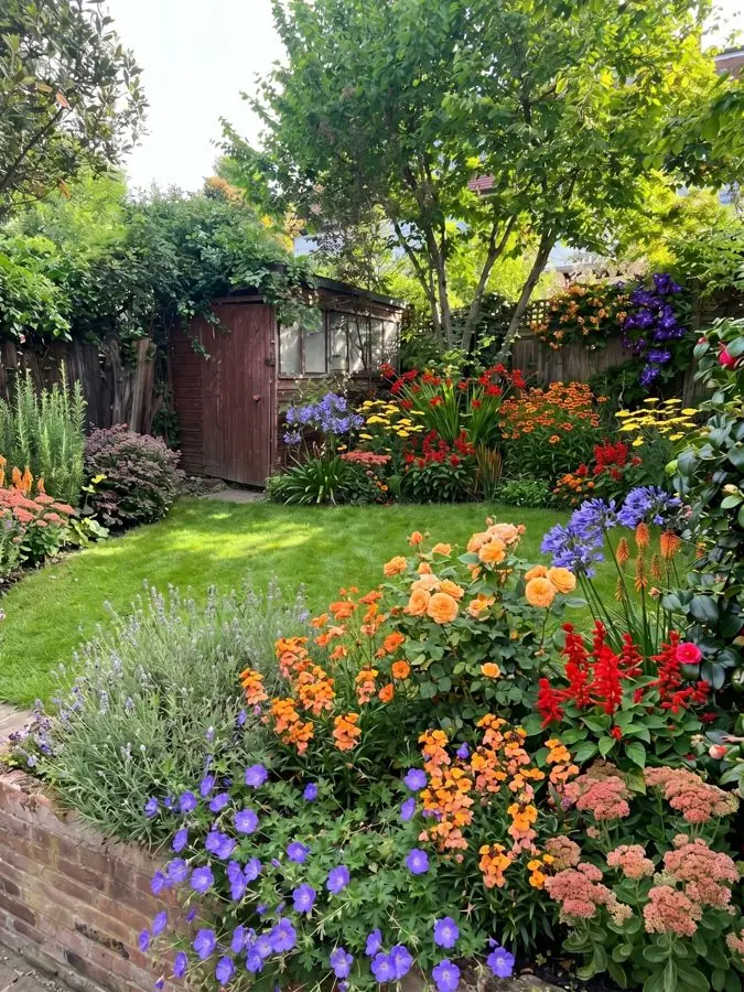 Hot coloured raised border by a lawn, redesigned