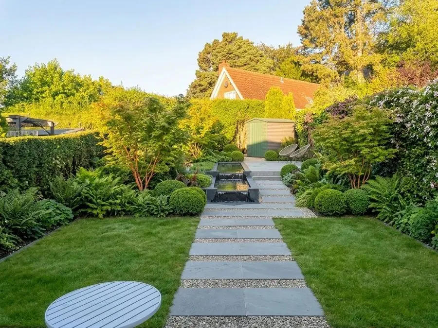 Stepping slabs across a lawn to the hedge, redesigned