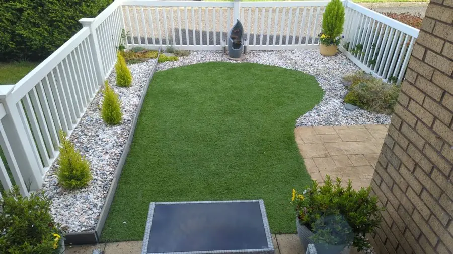 A curved lawn edged with white gravel and small conifers, before the redesign