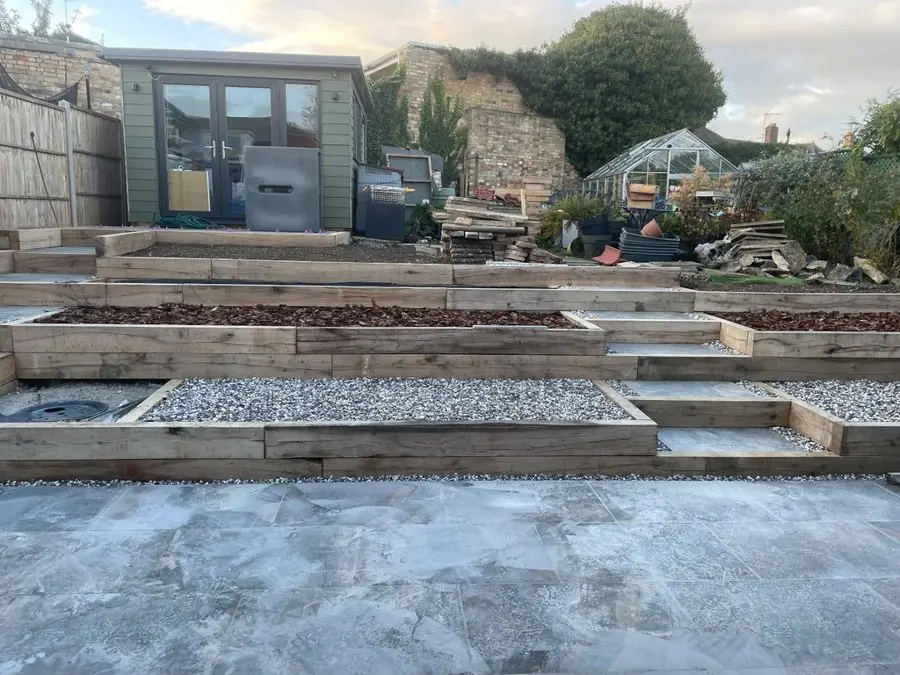 Empty sleeper terraces of gravel and steps below a summer house, before the redesign