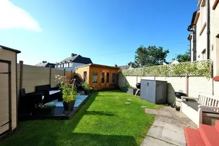 A lawn with a seating area, a summer house and a shed, before the redesign