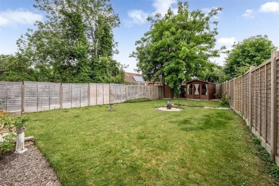 A long lawn between panel fences with a summer house at the end, before the redesign