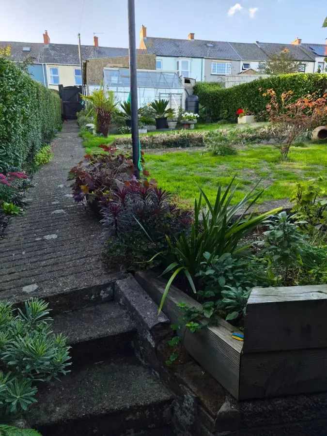 Brick steps beside a sleeper bed leading up to a lawn, before the redesign