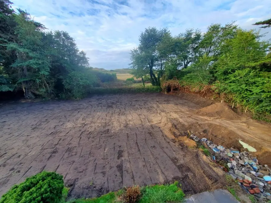 A large patch of bare levelled earth with rubble at the edge, before the redesign