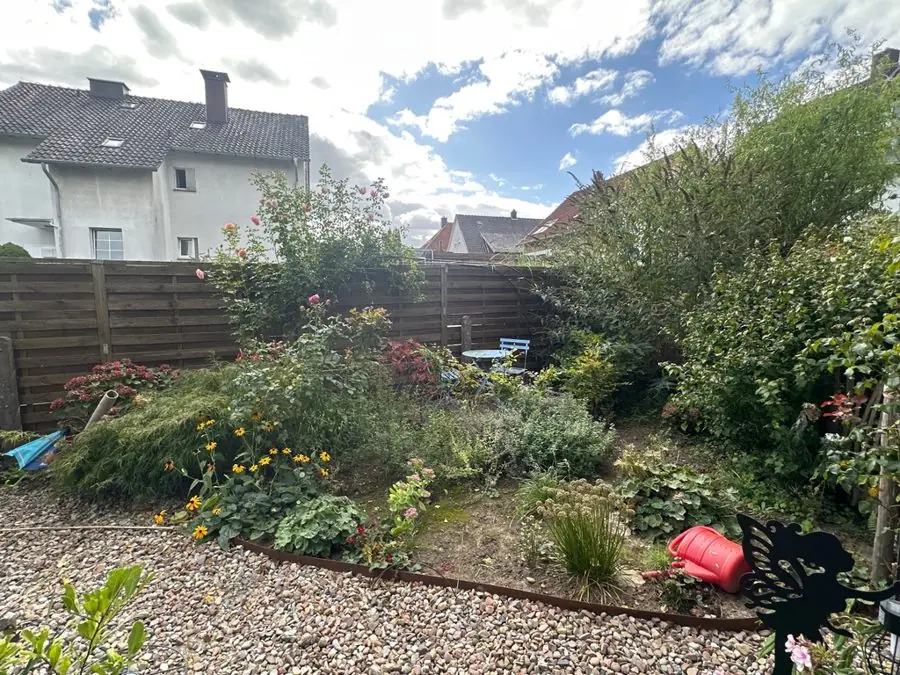 A mixed border beside gravel, in front of a wooden fence, before the redesign