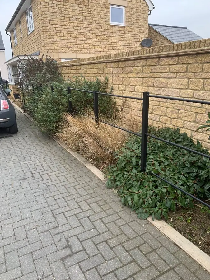 A narrow strip of grasses and shrubs beside a block paved drive, before the redesign