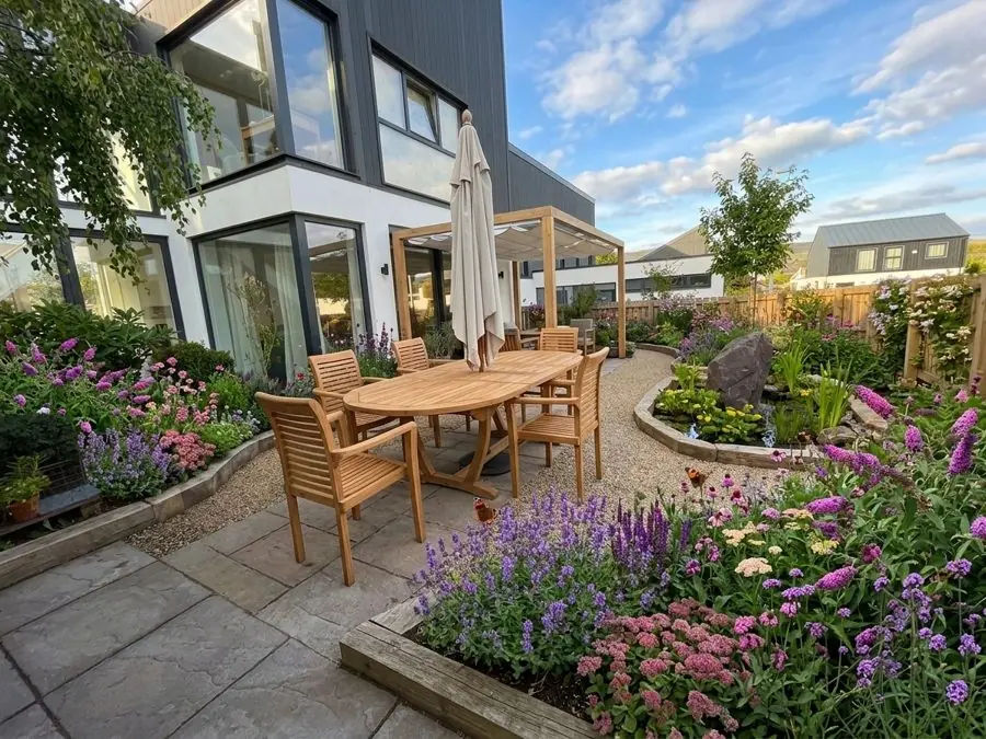 Curved flower beds and gravel round a dining patio, designed with the app