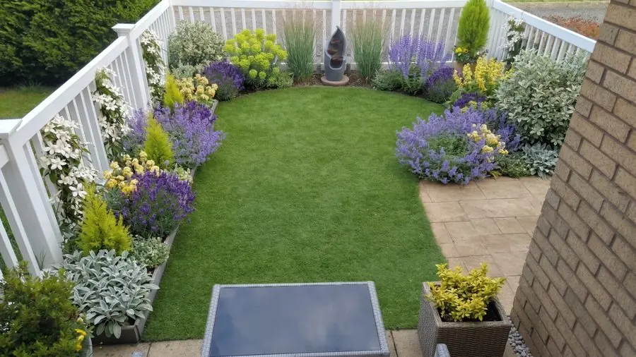 A curved lawn edged with lavender, silver leaves and small conifers inside a white rail, designed with the app