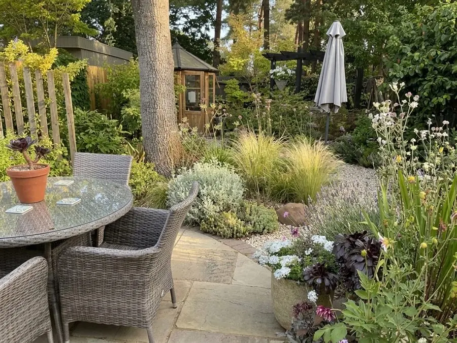 Gravel, grasses and silver plants beside a patio table, redesigned with the app