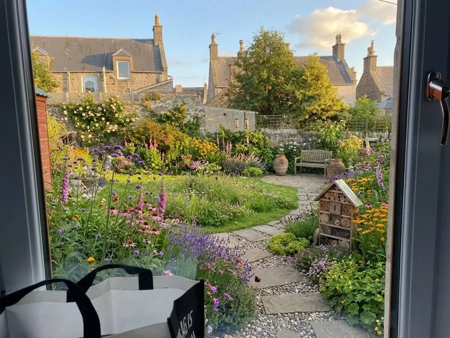 Long grass, flowers and a bug hotel, a wildlife garden idea