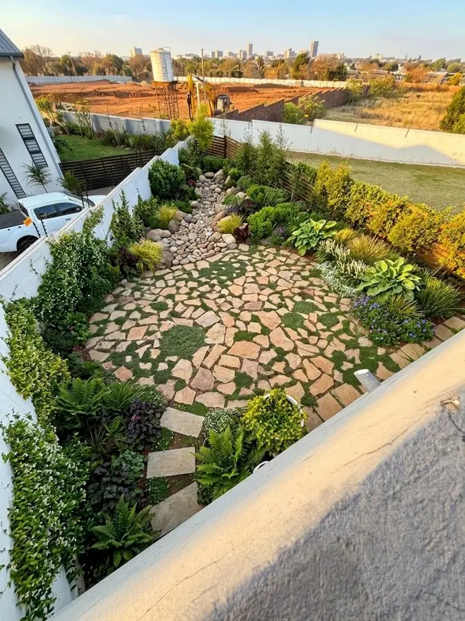 Seen from upstairs: a crazy paving circle among dense planting, designed with the garden design tool