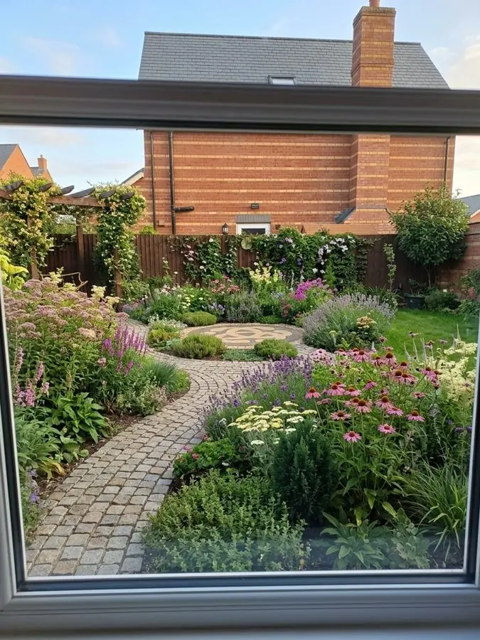 Seen through the window: a cobbled path through flowers for bees to a round seating area, designed with the app