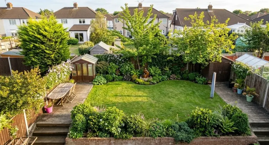 A square lawn reshaped into a curve, with evergreen shrubs filling the corners, from upstairs, redesigned with the app